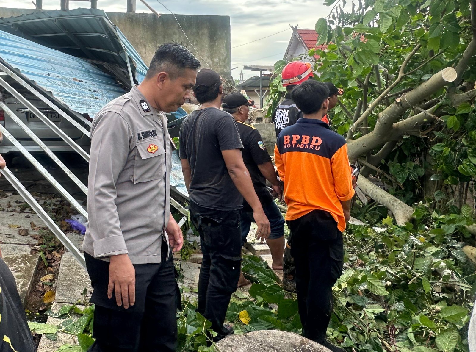 Tim Polres Kotabaru Bersama Warga Bersihkan Pohon Tumbang Akibat Angin Kencang  Yang Timpa Mobil